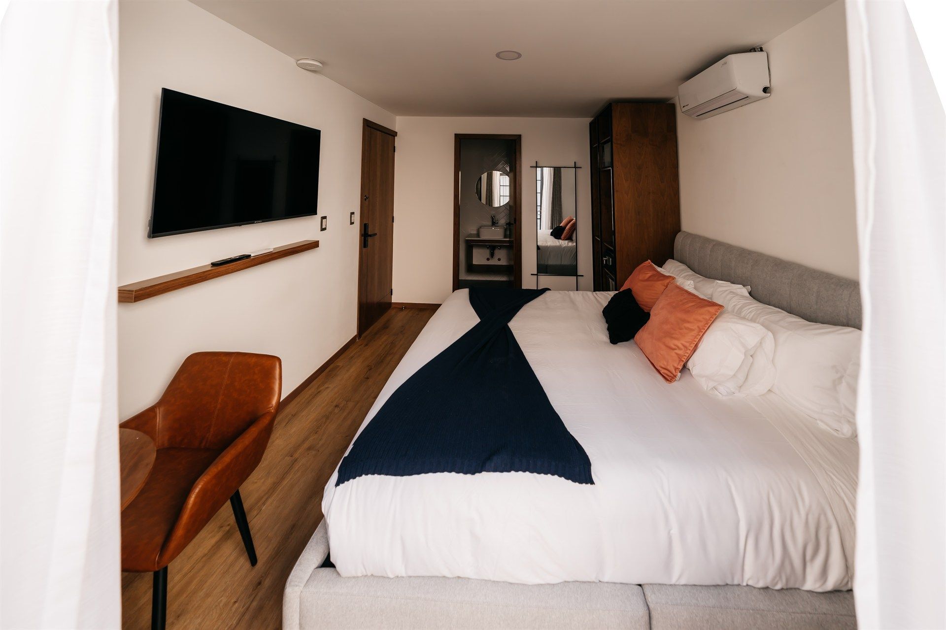 Una habitación de hotel con una cama grande y un televisor de pantalla plana.