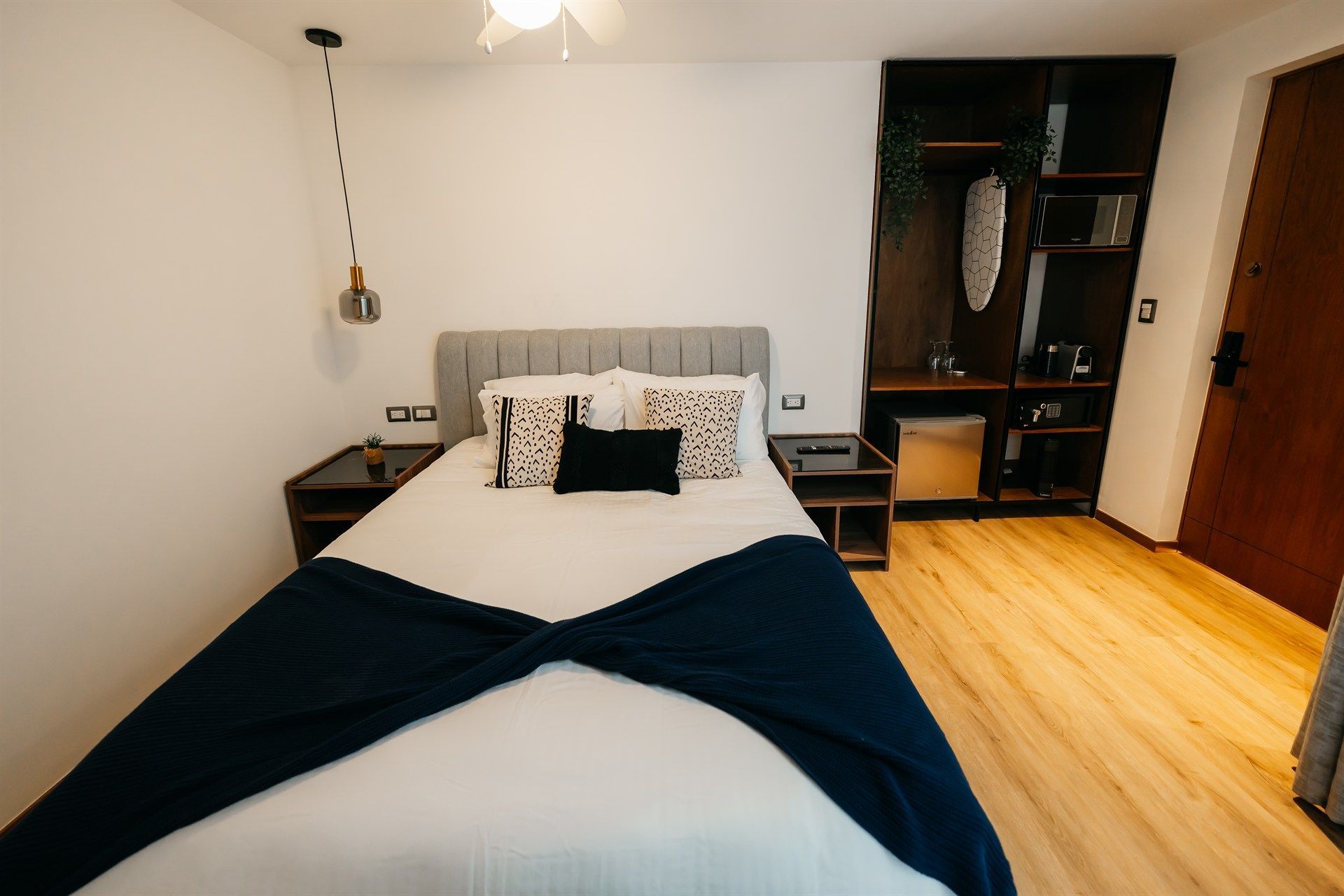 Un dormitorio con una cama grande y suelo de madera.