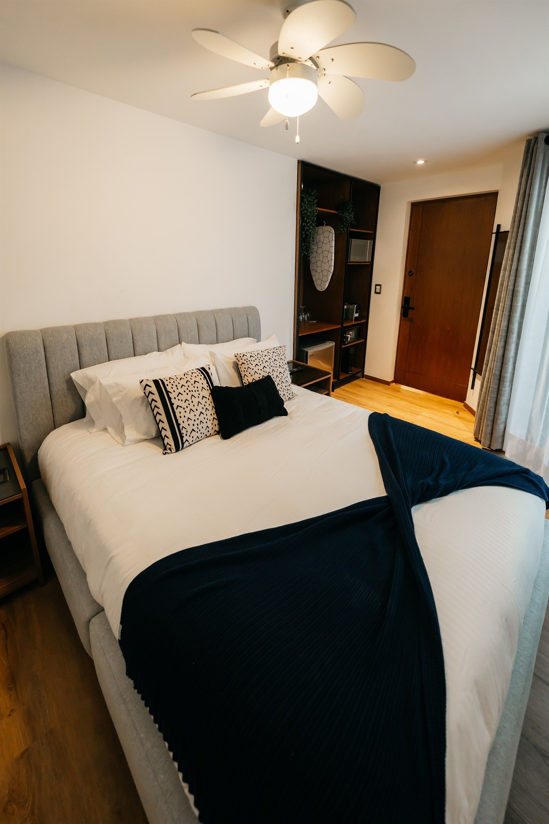 Un dormitorio con una cama y un ventilador de techo.