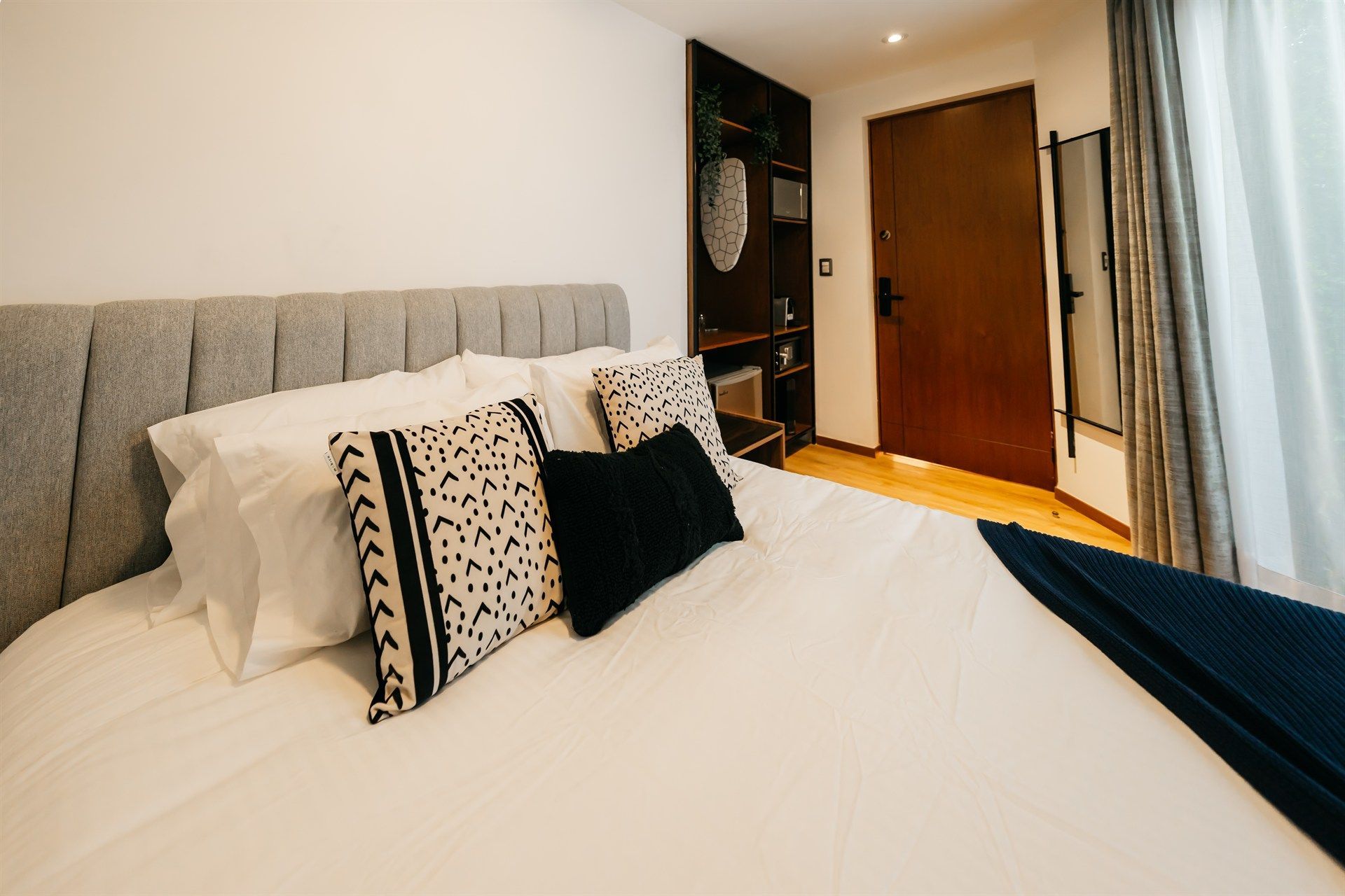 Un dormitorio con una cama, almohadas y una puerta.