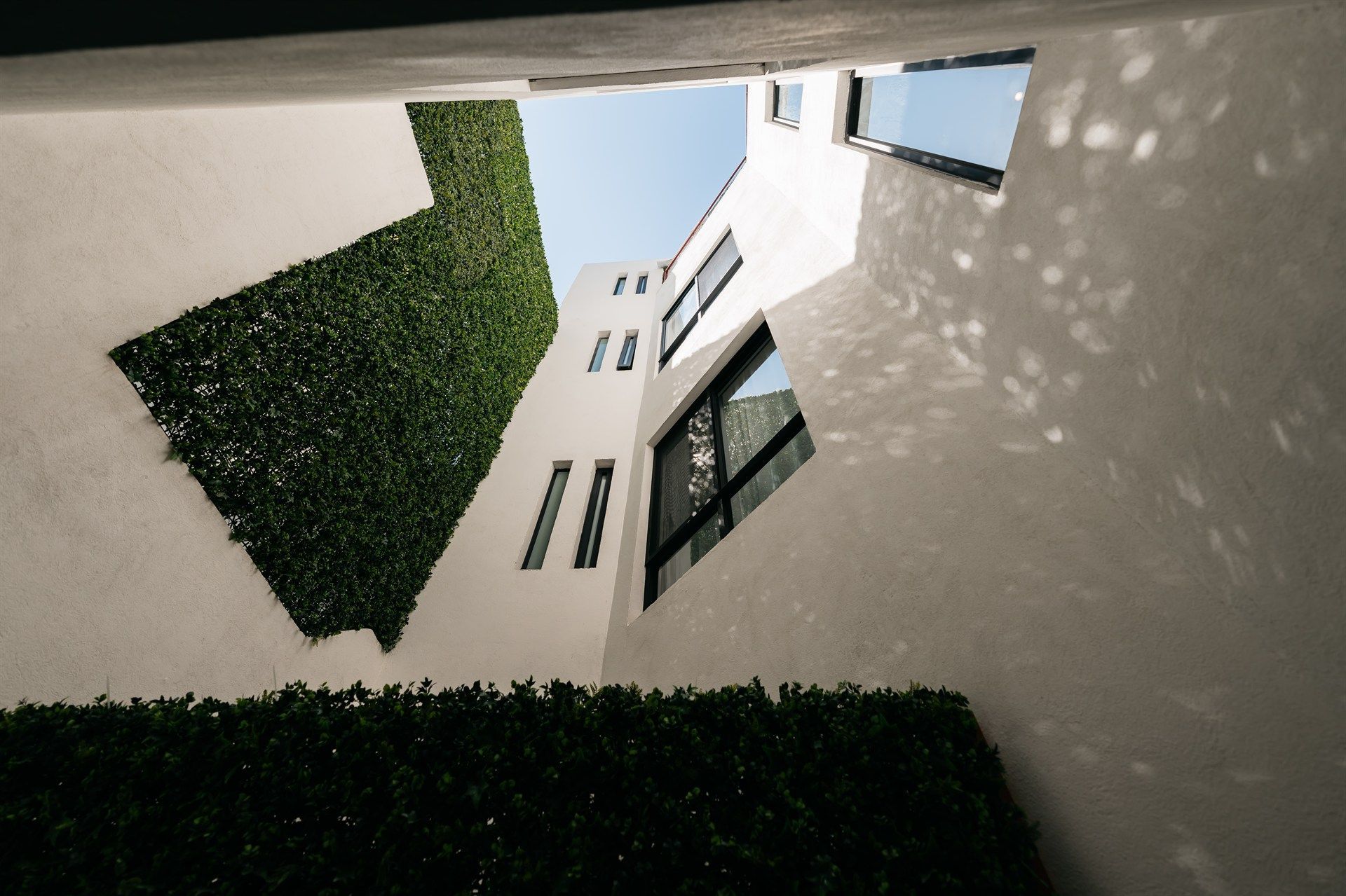 Mirando hacia arriba a un edificio con un seto delante