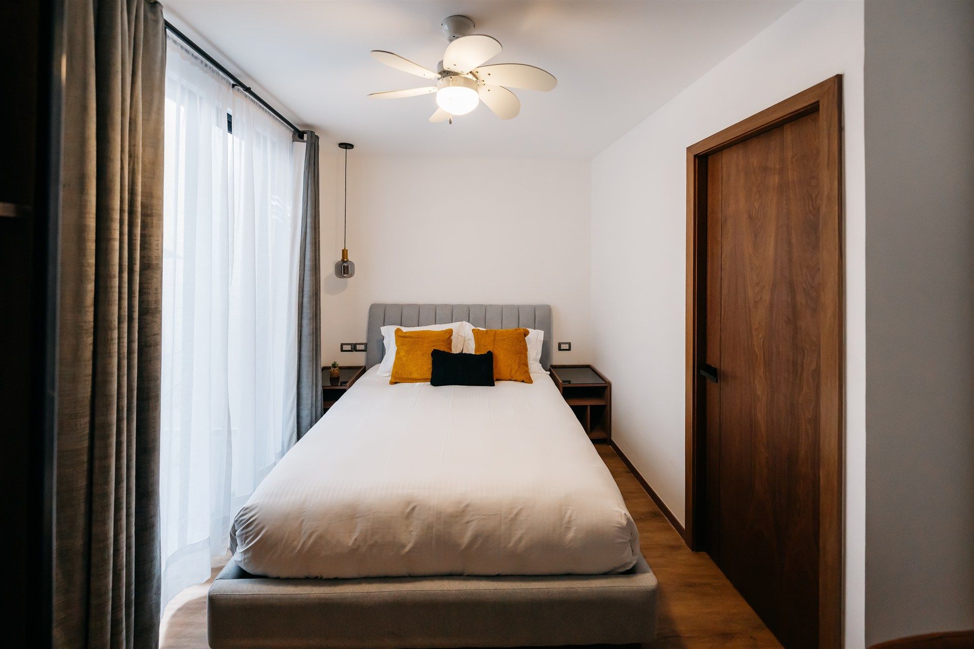 Un dormitorio con una cama y un ventilador de techo.