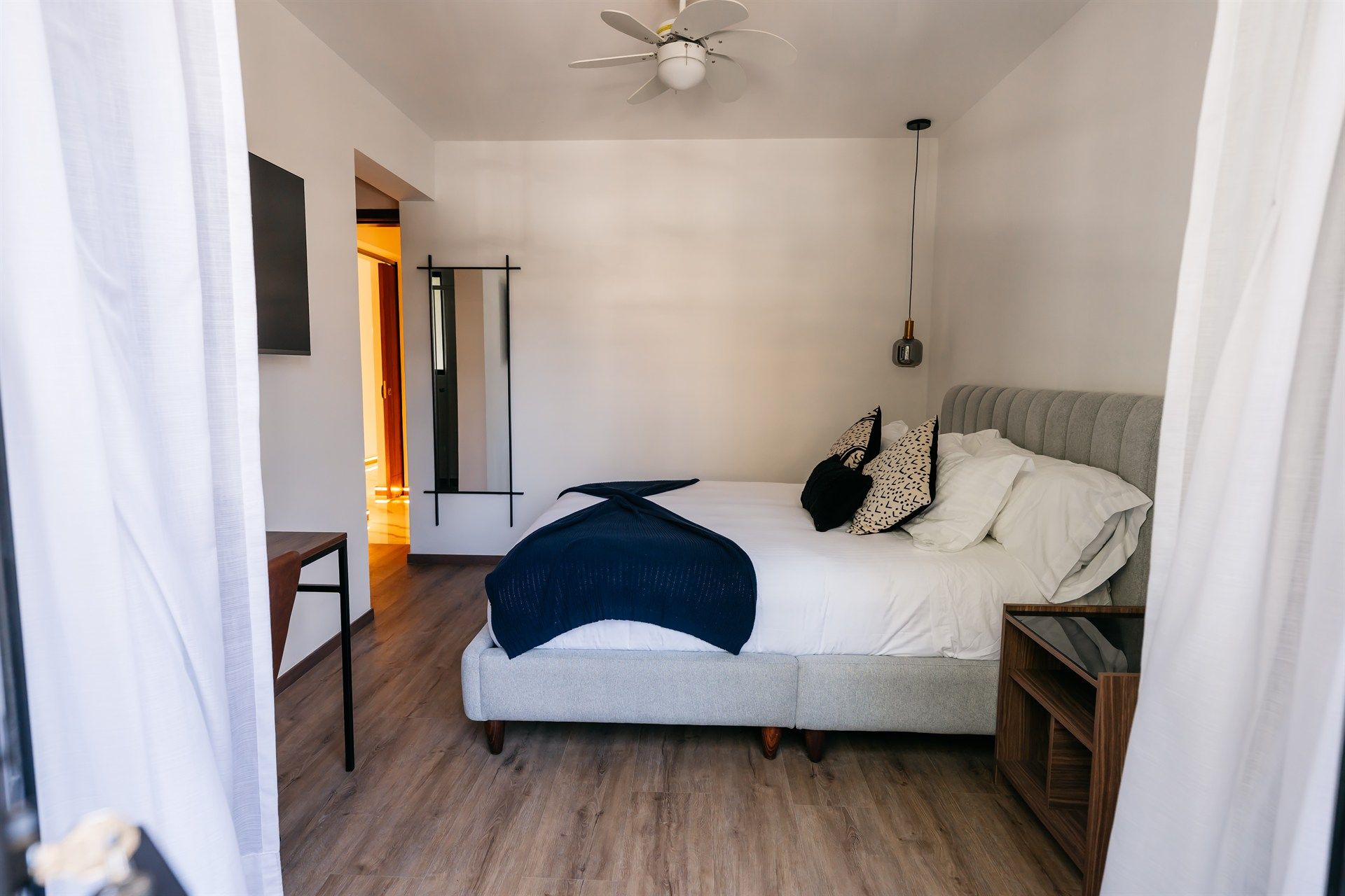 Un dormitorio con una cama grande y un ventilador de techo.