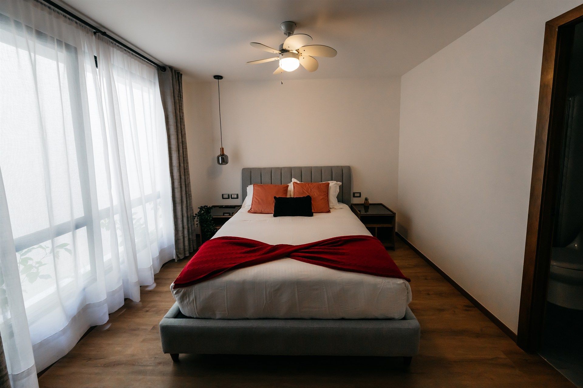 Un dormitorio con una cama grande y un ventilador de techo.