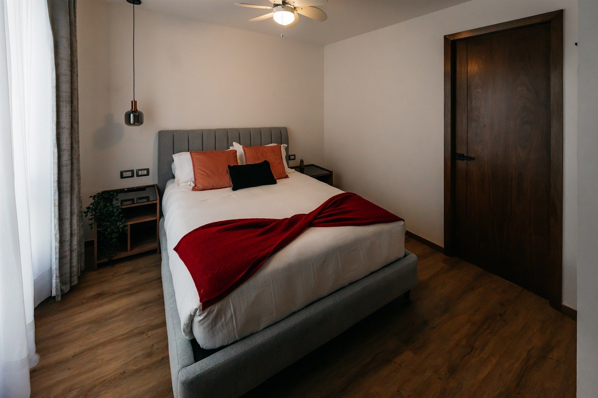 Un dormitorio con una cama grande y un ventilador de techo.