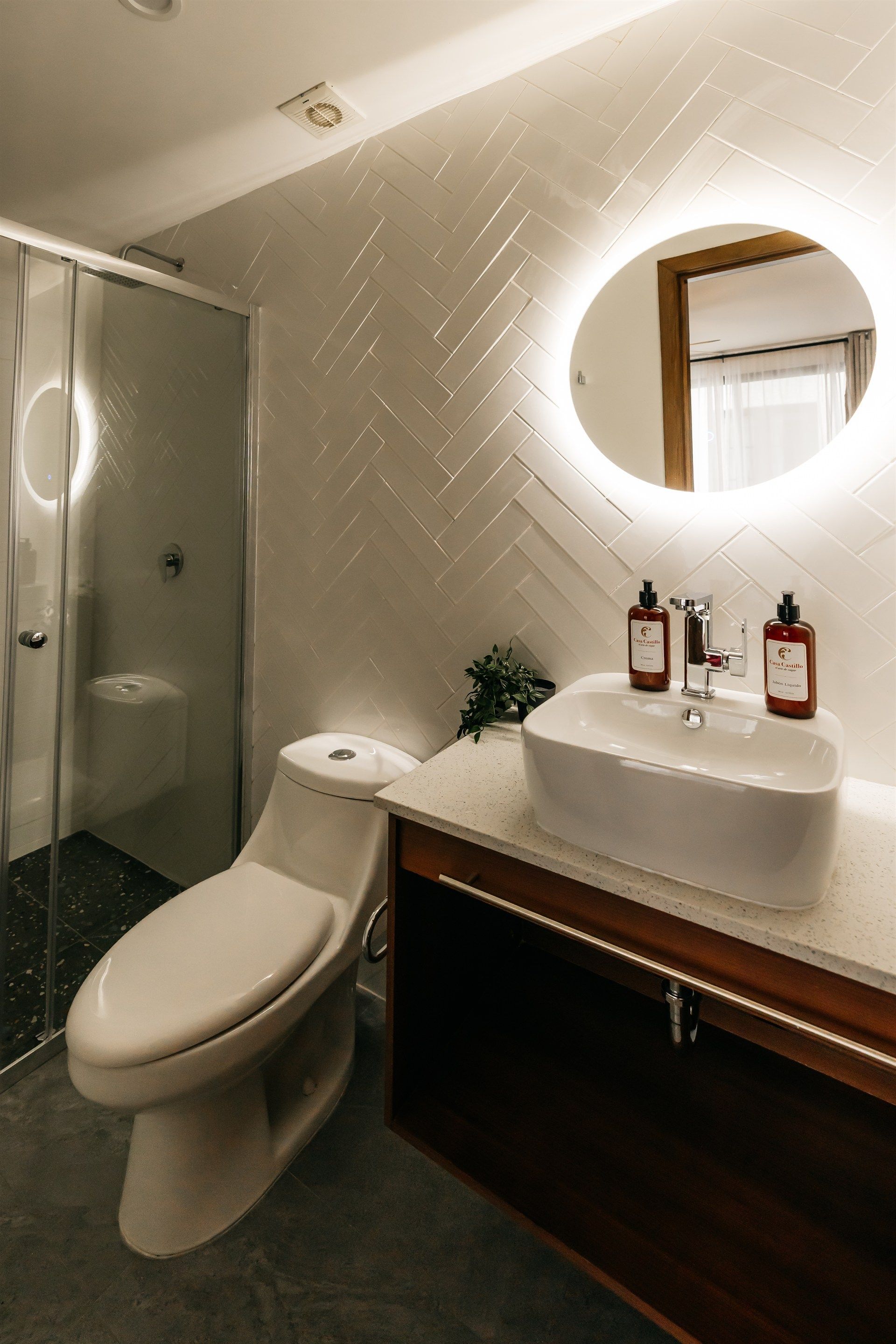 Un baño con inodoro, lavabo y ducha.