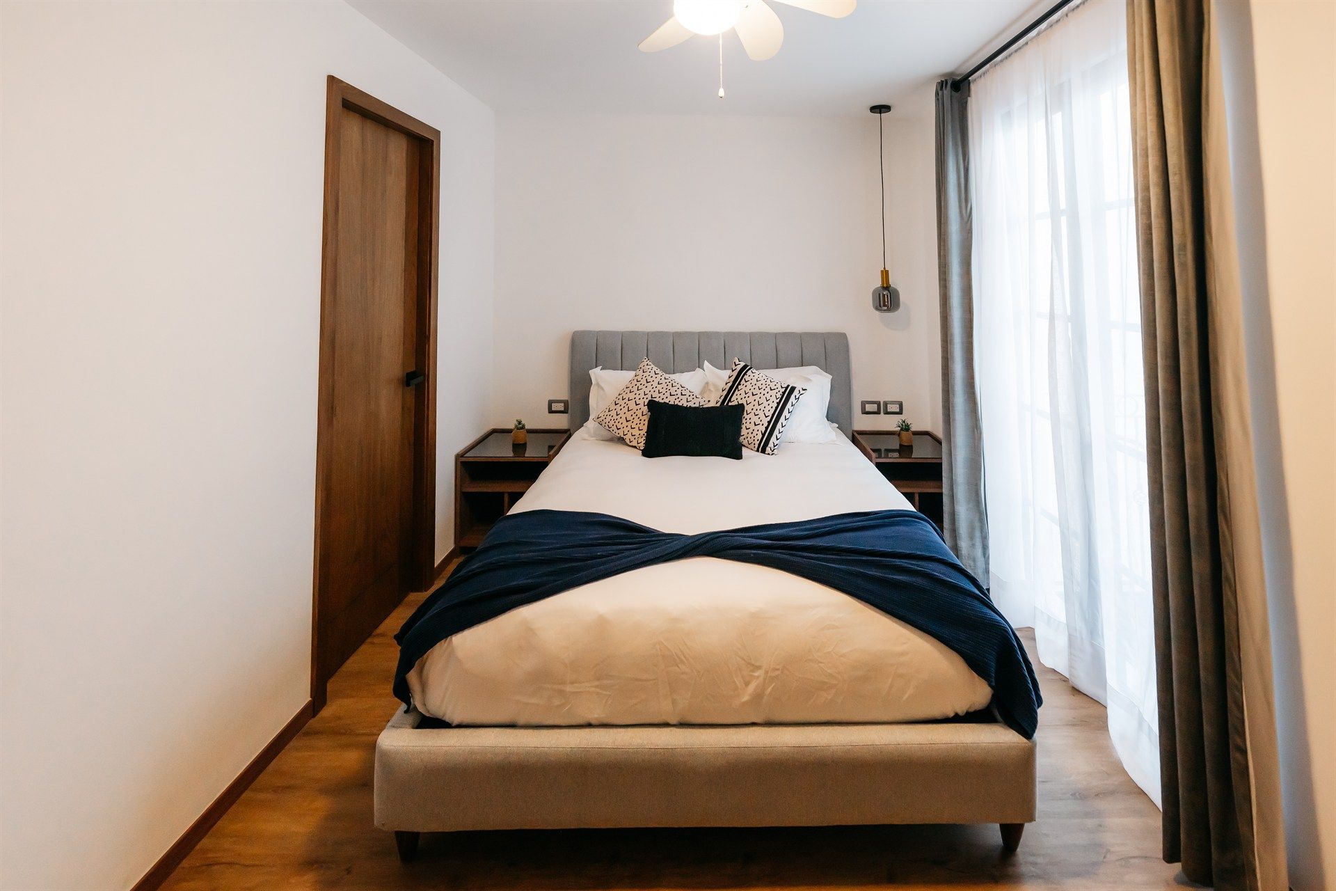 Un dormitorio con una cama grande y un ventilador de techo.