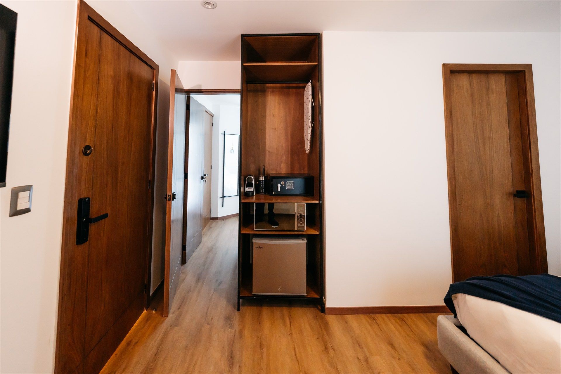 Una habitación de hotel con una cama, un refrigerador y un vestidor.
