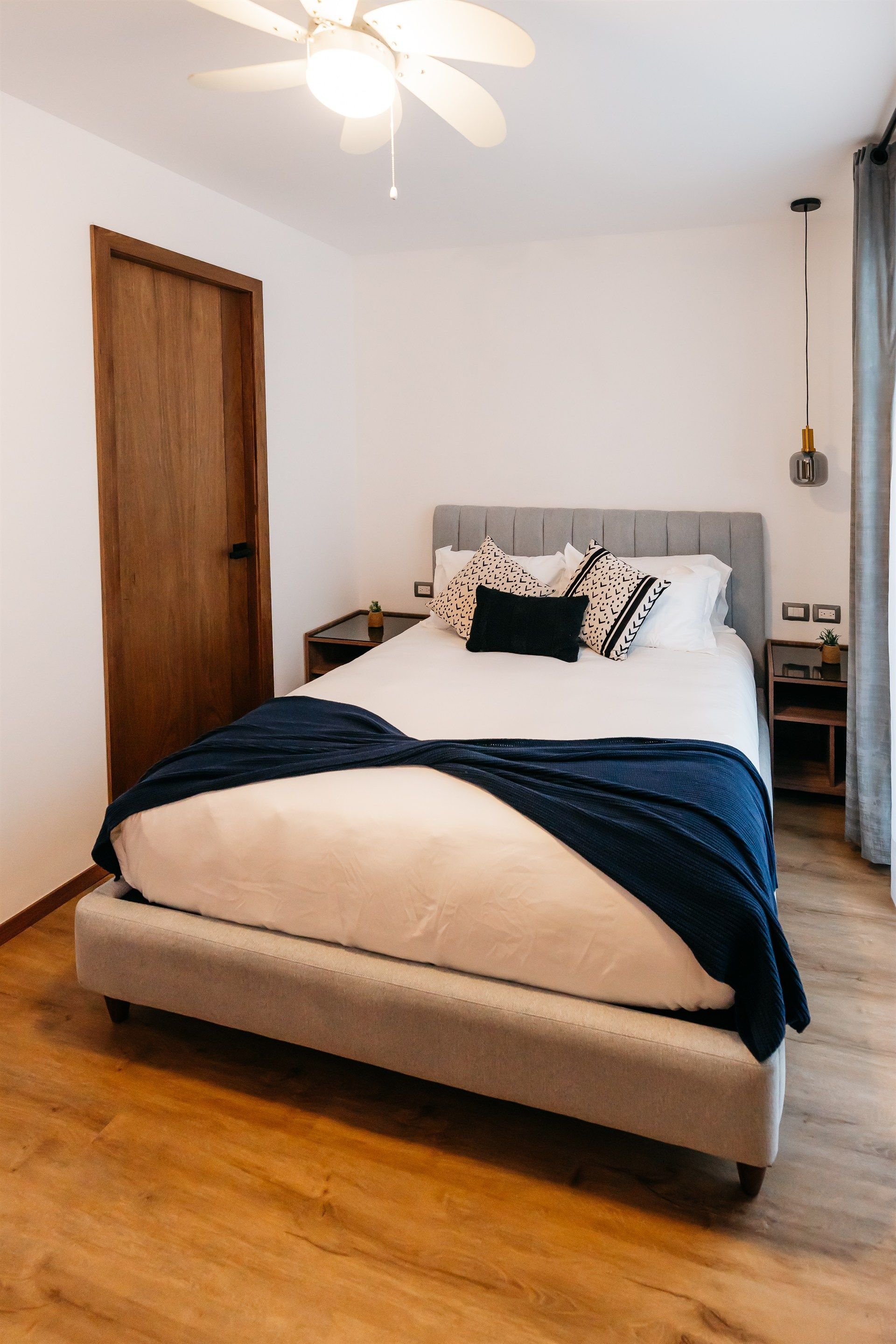 Un dormitorio con una cama y un ventilador de techo.