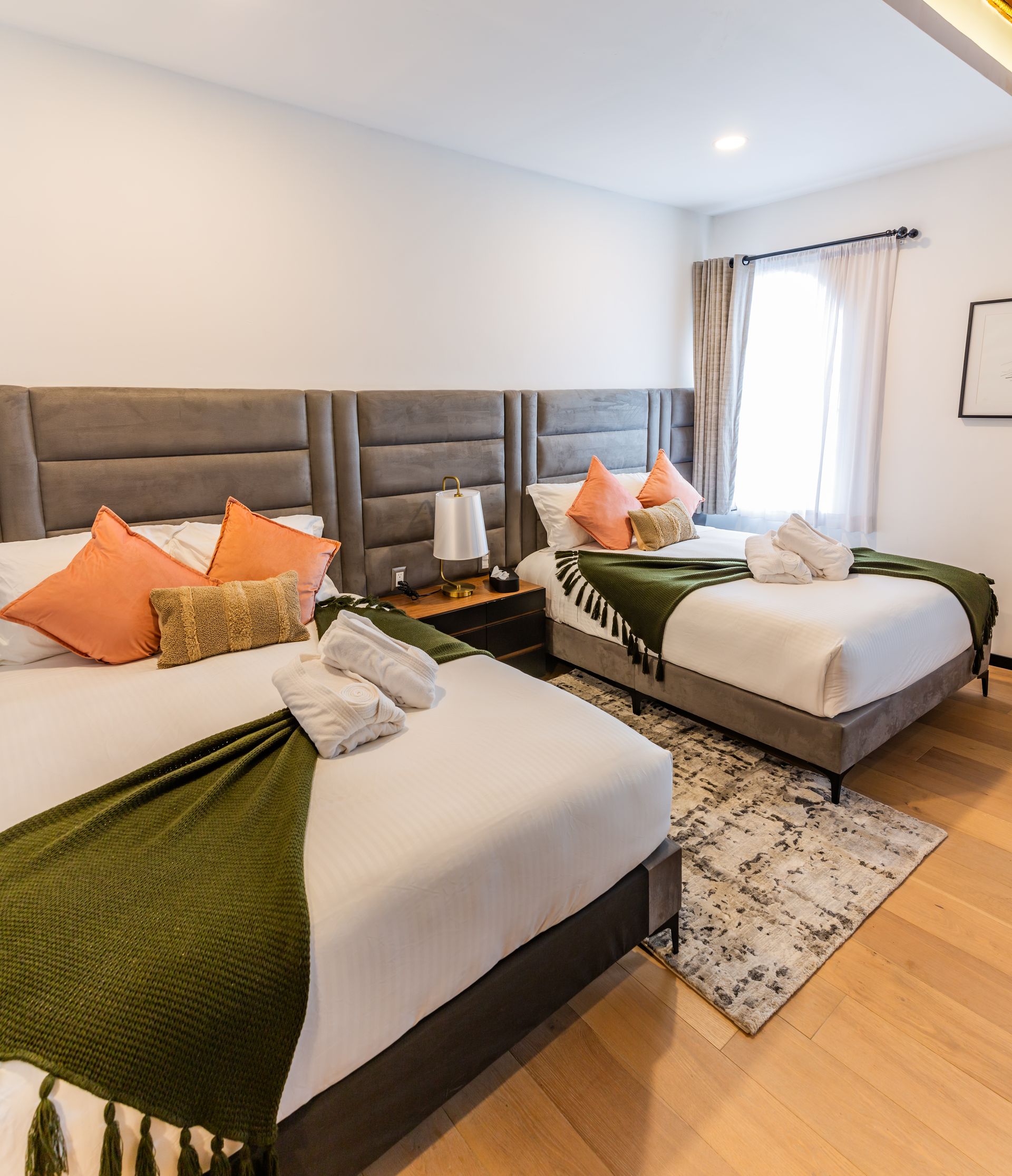 A hotel room with two beds and a rug.
