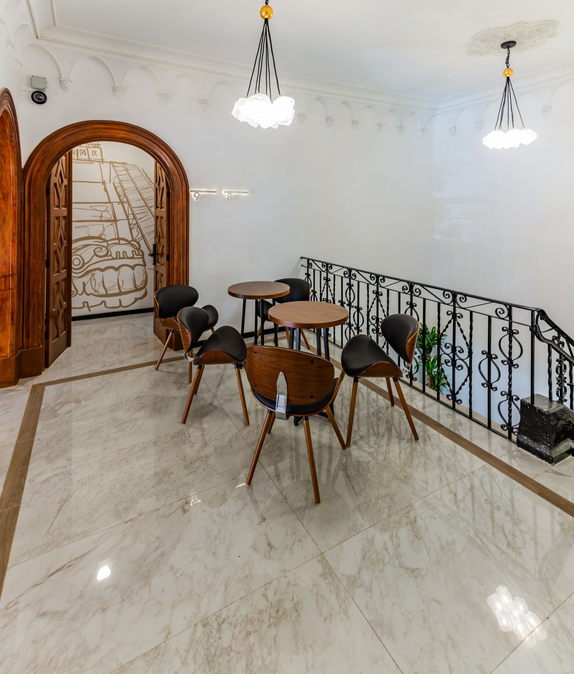 A room with tables and chairs next to a staircase