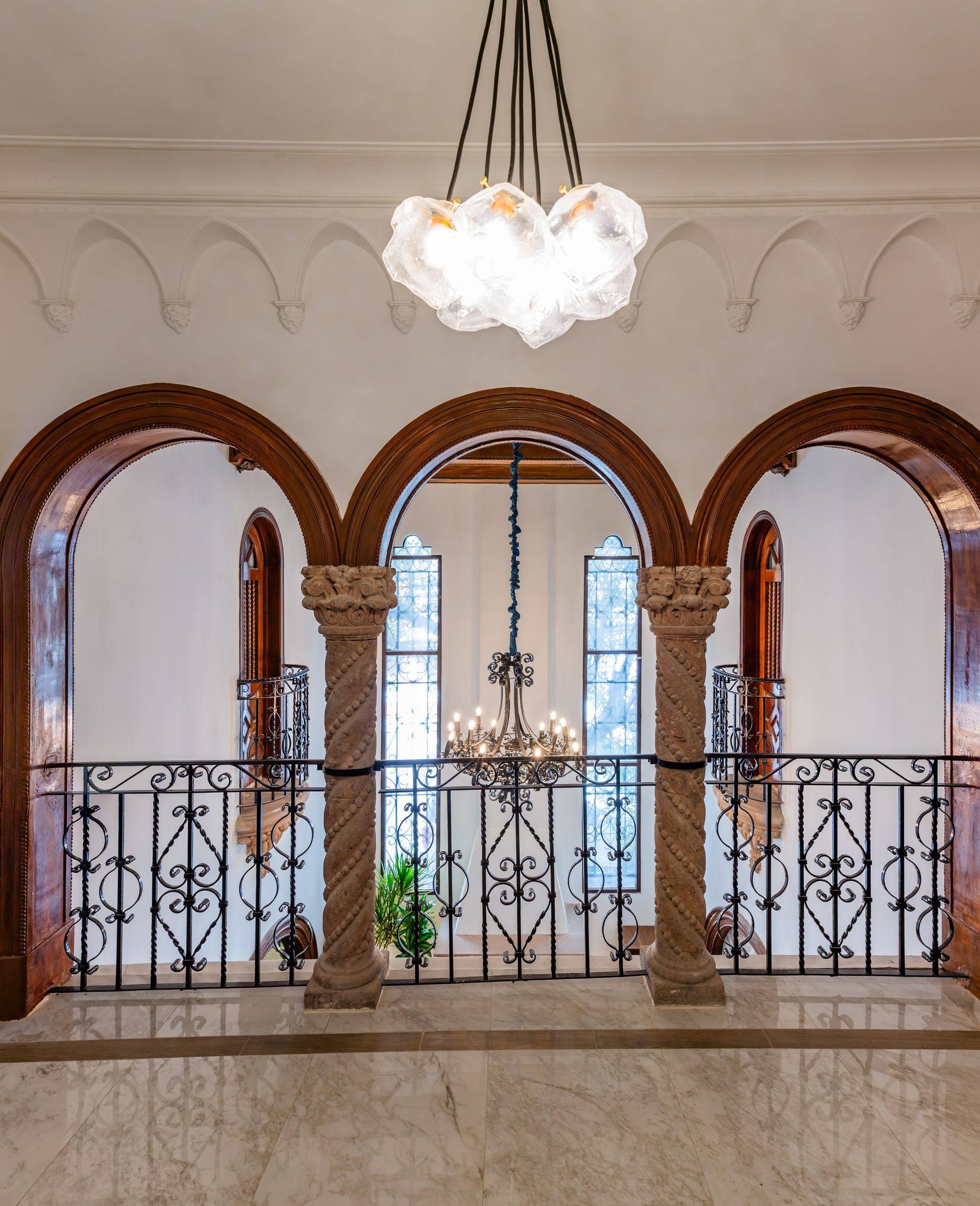 A room with arches and a chandelier hanging from the ceiling