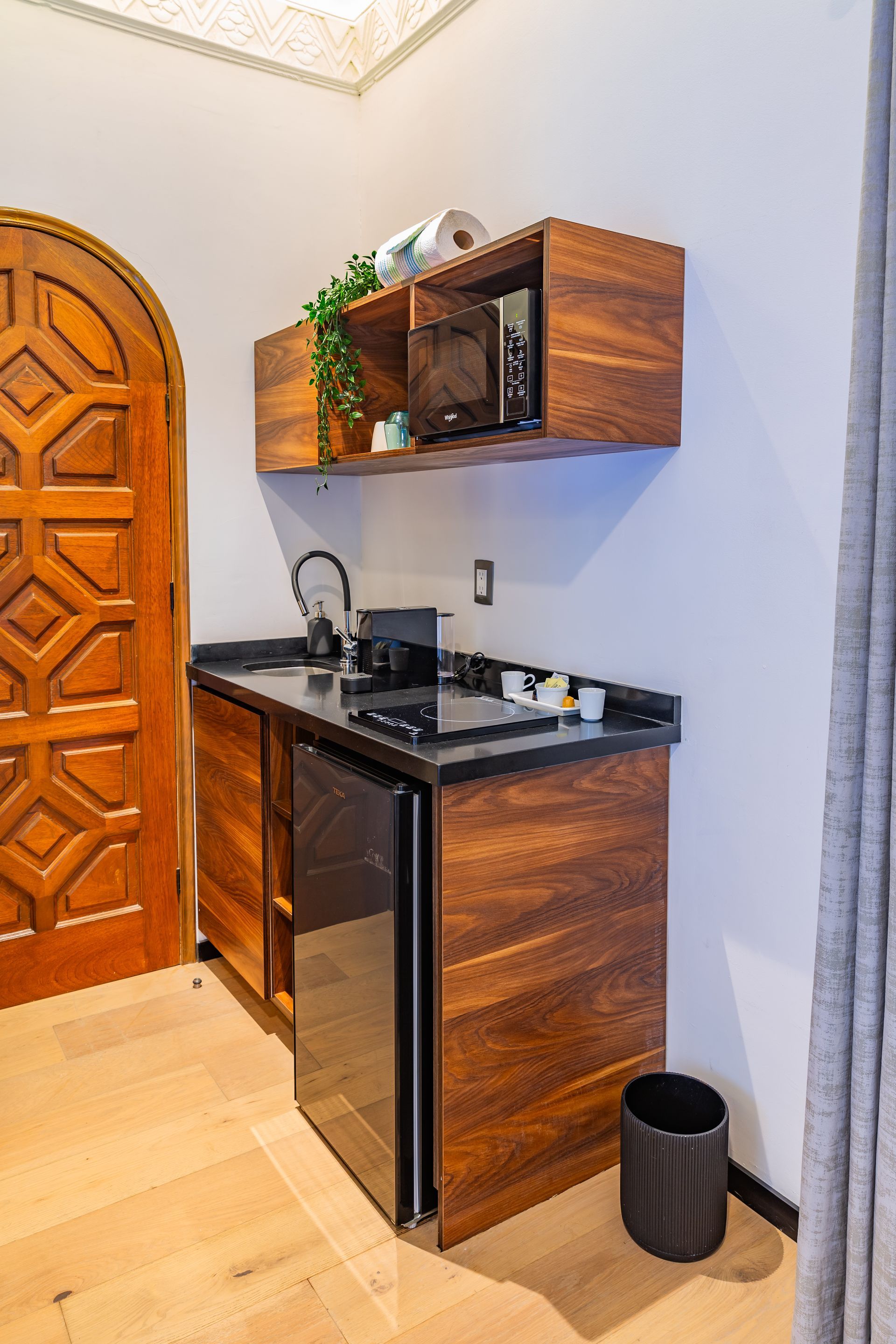 A kitchen with wooden cabinets , a refrigerator , a sink , and a microwave.
