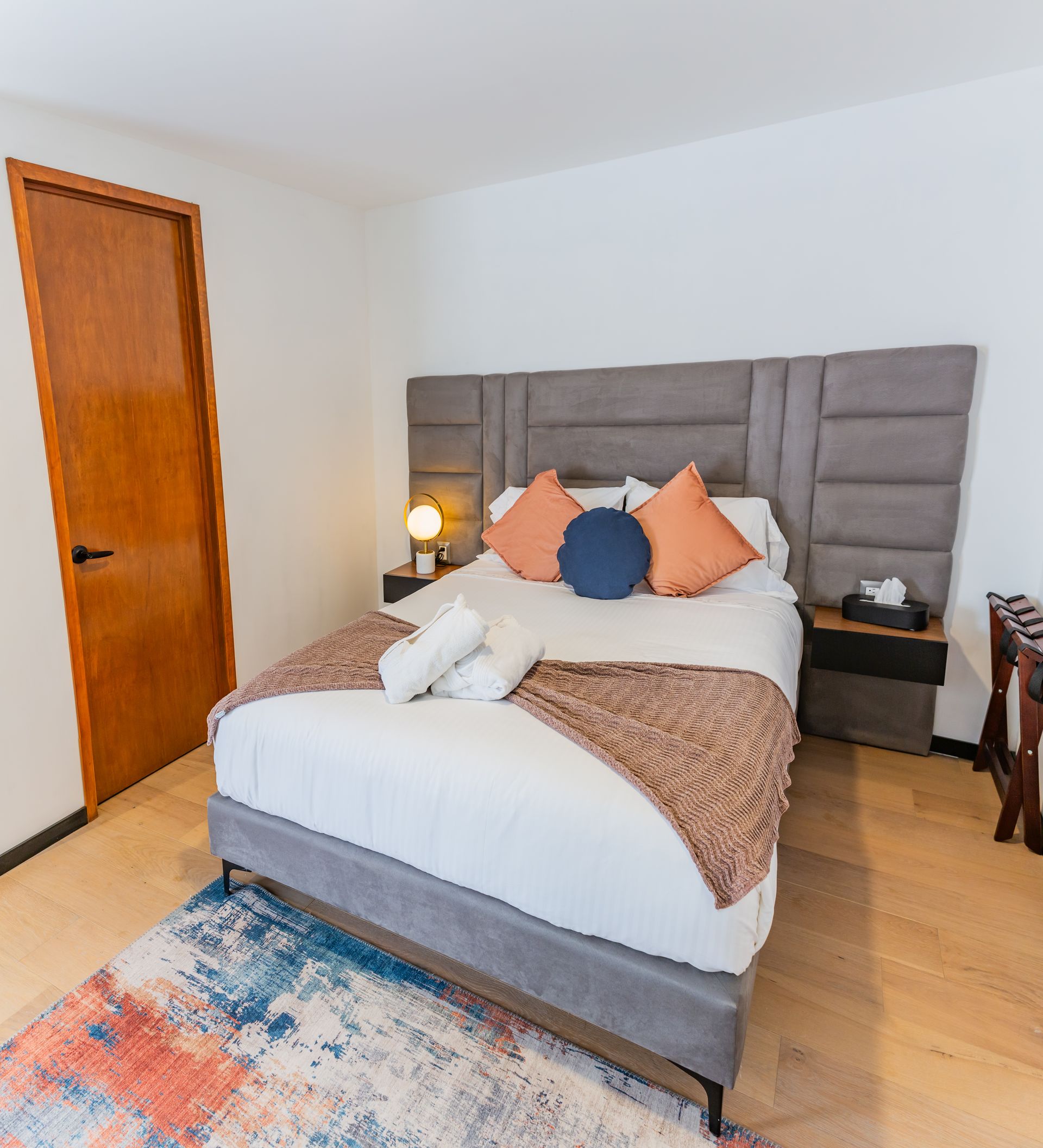 A hotel room with a king size bed and a rug.
