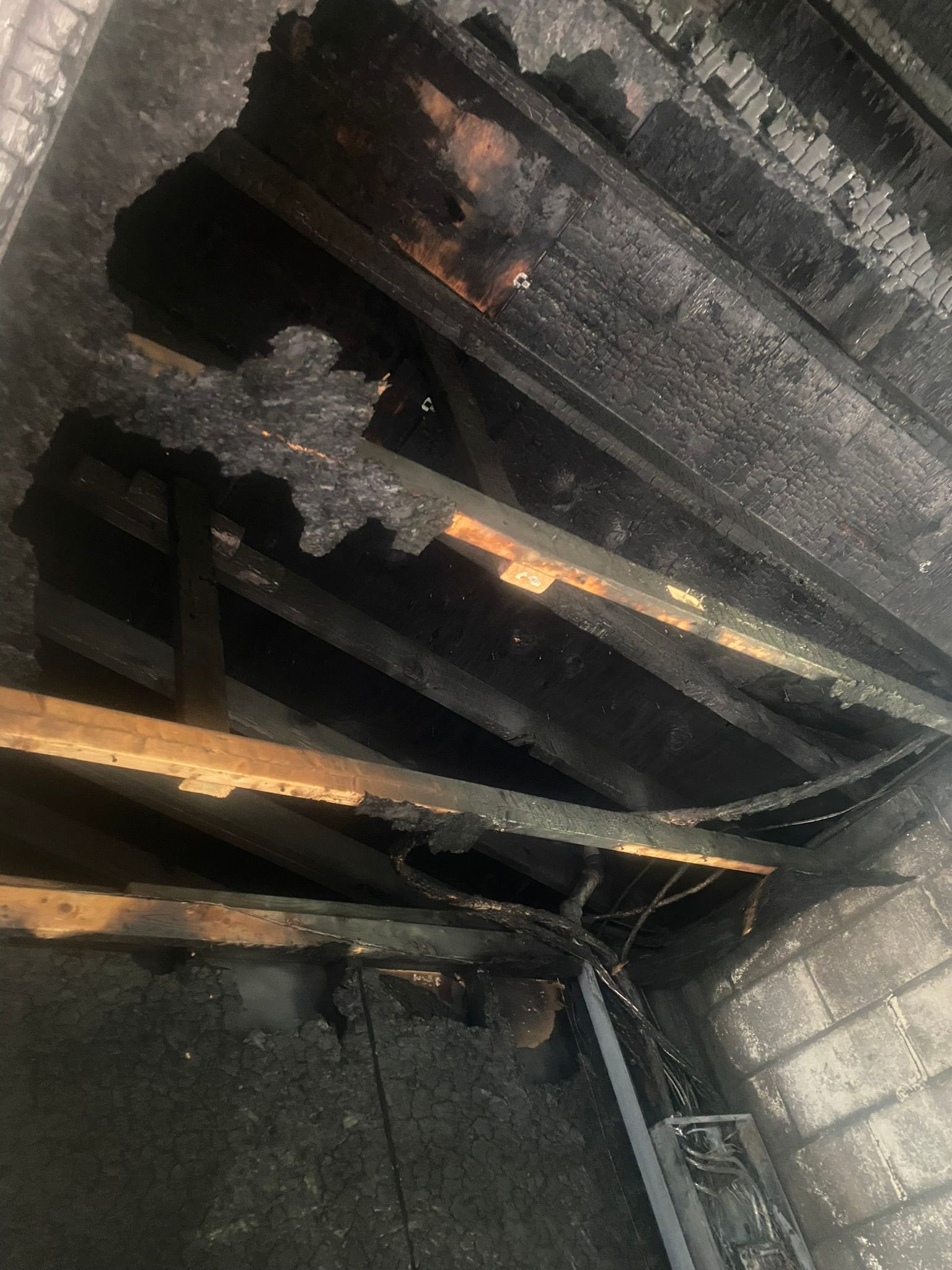 Moldy wood next to pink insulation and blue material.