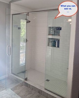 Glass shower with white tile walls, a recessed shelf, and a tiled floor.