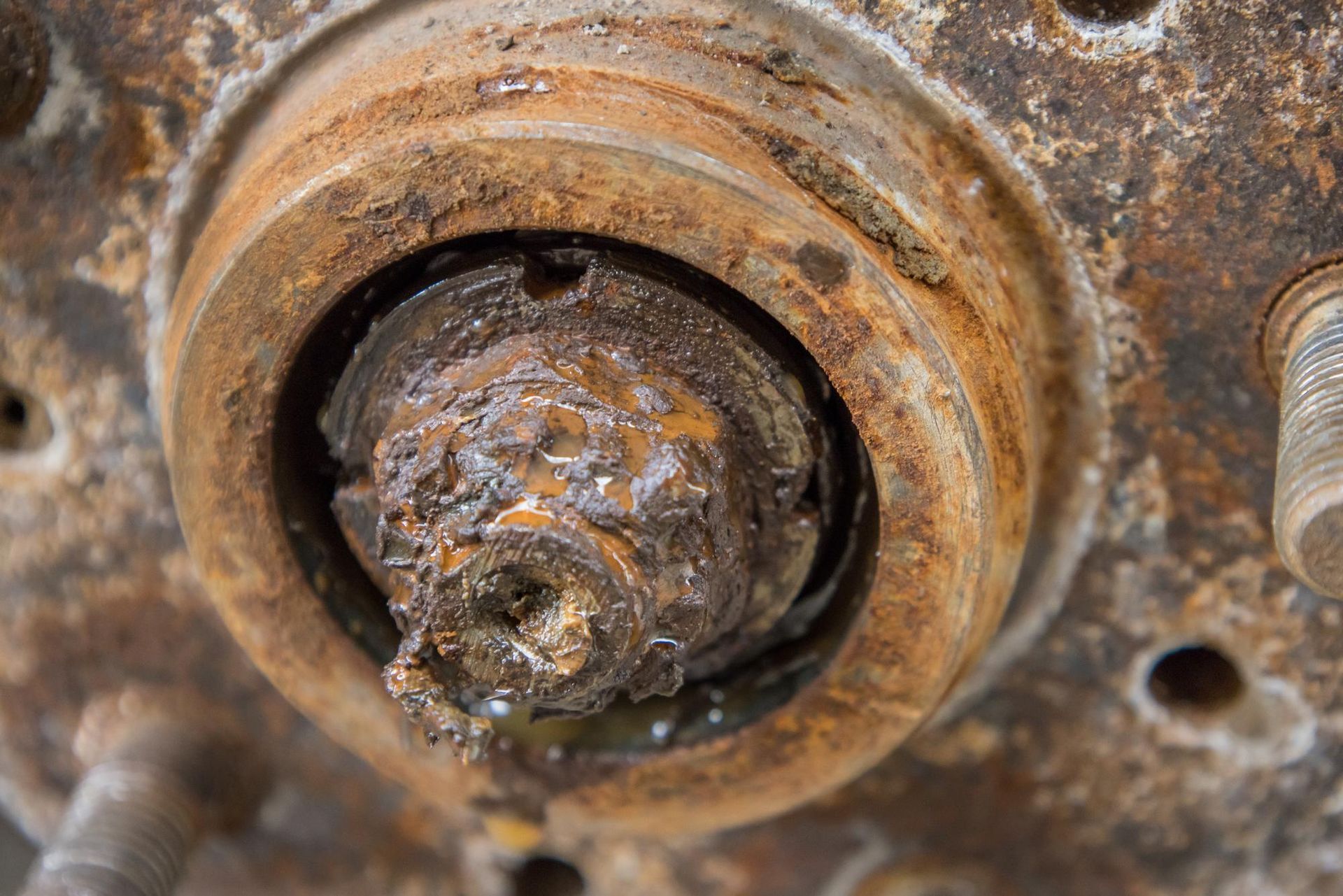 A close up of a rusty wheel bearing on a car.