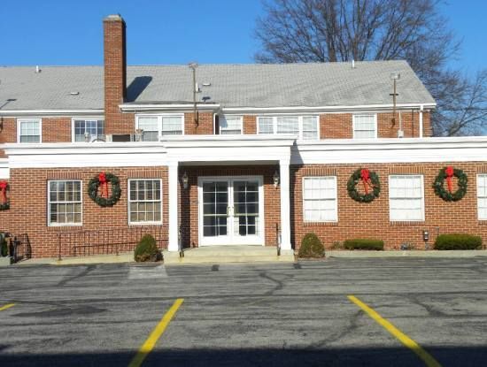 A brick building with christmas wreaths on the windows