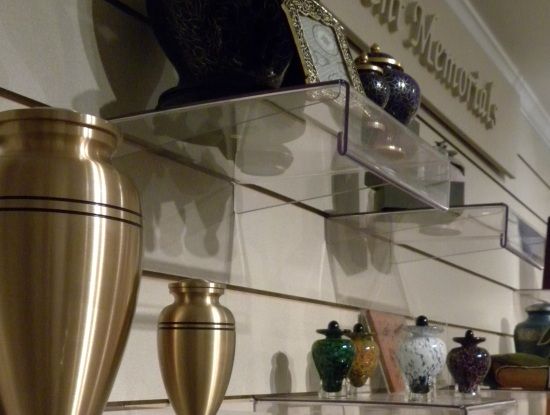 A display of urns and vases with a sign that says memorials