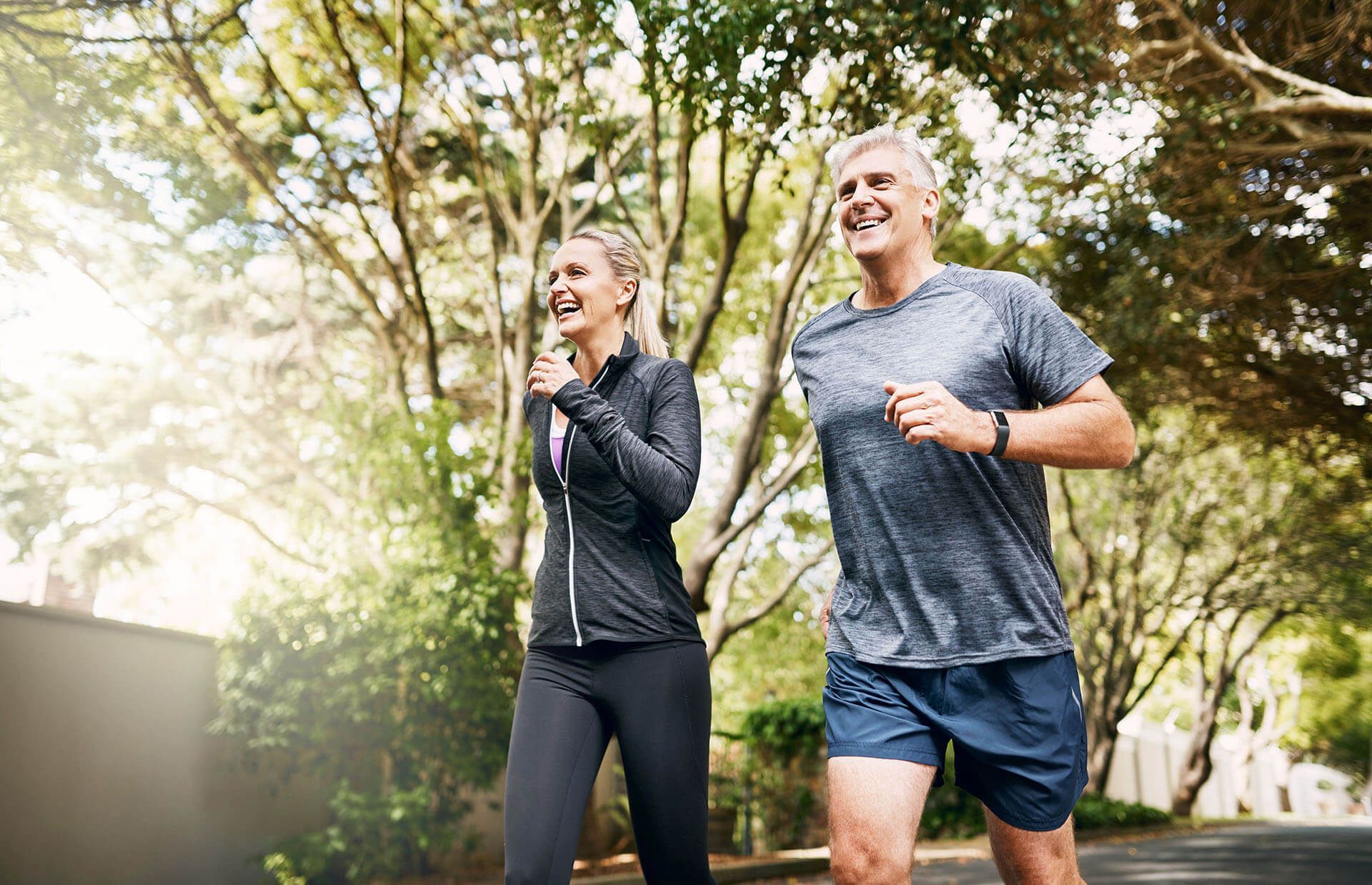 A man and a woman are jogging on a street.