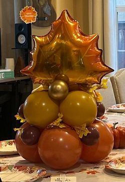 A bunch of colorful balloons are hanging on a white curtain.