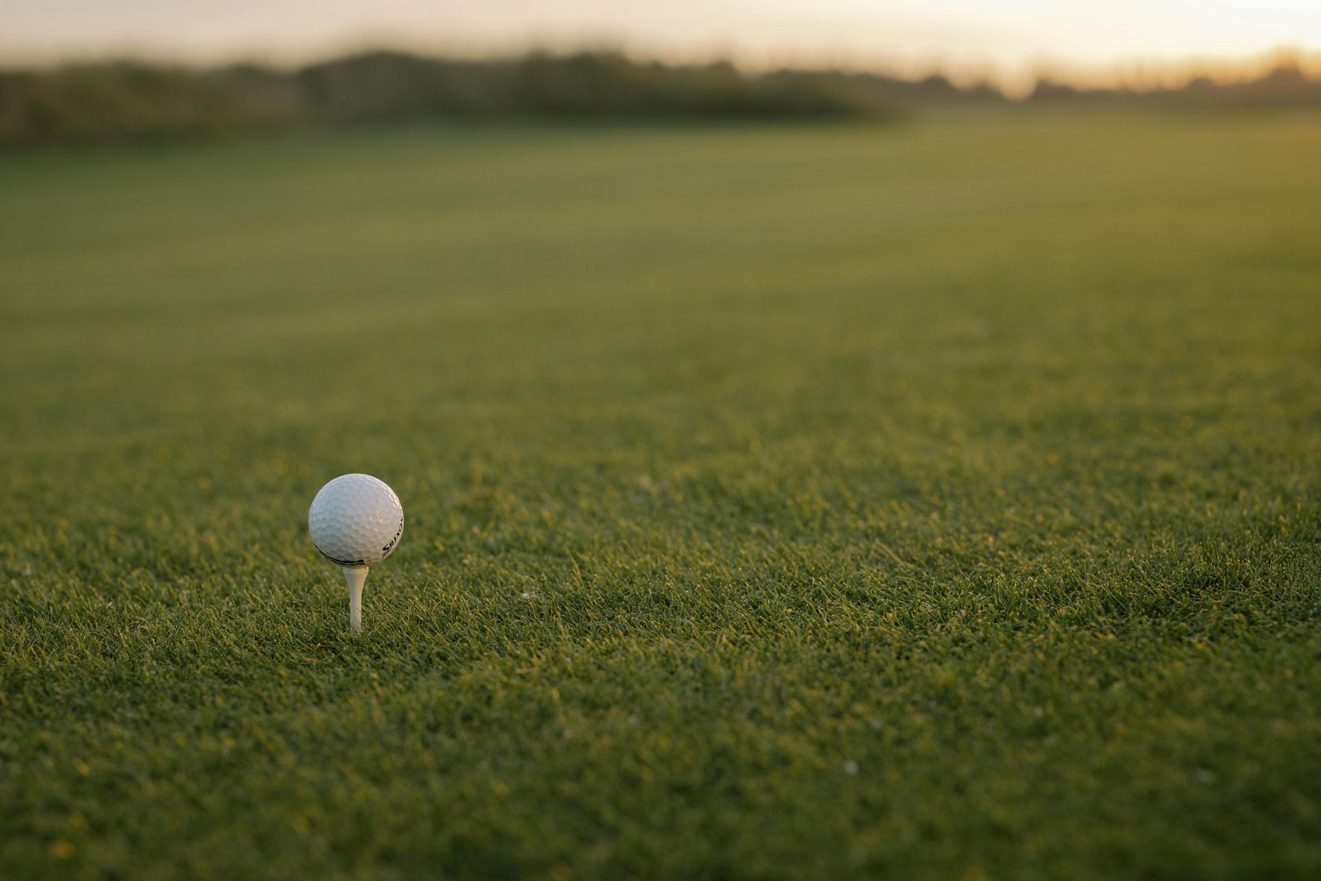 A golf ball is sitting on a tee on a golf course.