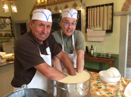 Two men are kneading dough together in a kitchen Two men are kneading dough together in a kitchen