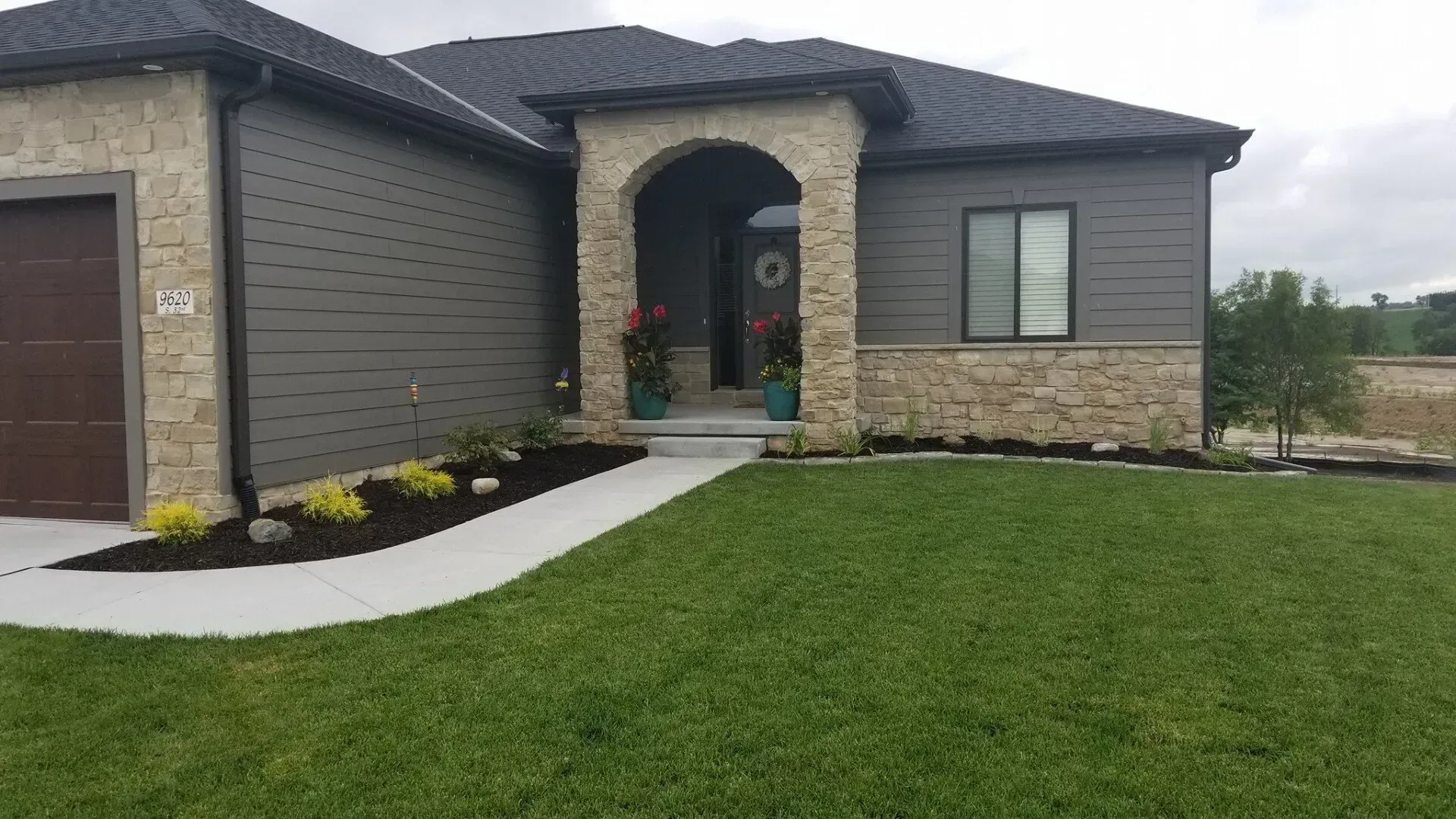 A house with a large lawn in front of it.