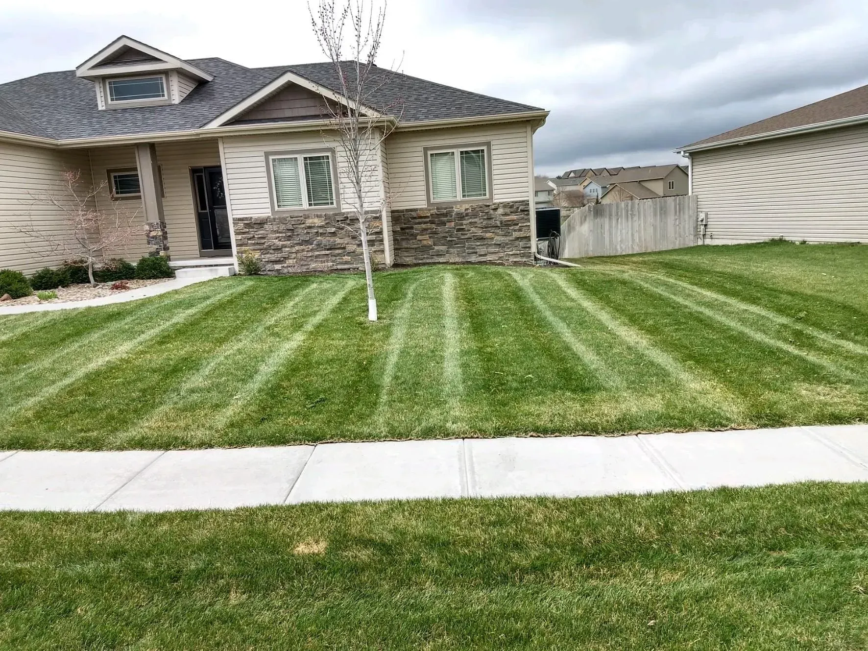 A house with a lush green lawn in front of it.