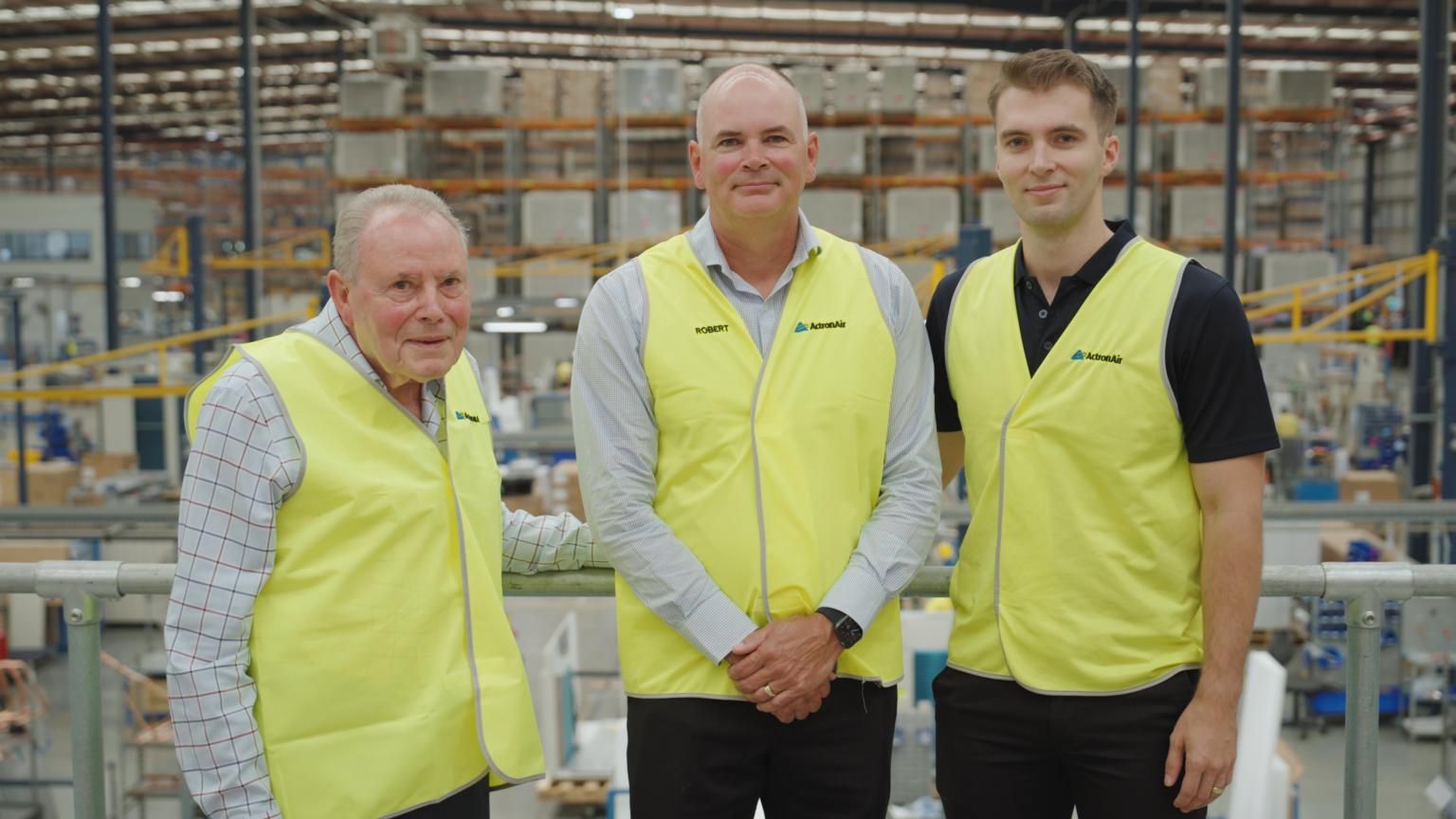 Three Men in Yellow Vests Are Standing Next to Each Other in a Warehouse — AJM's Air Conditioning Centre in Lismore, NSW