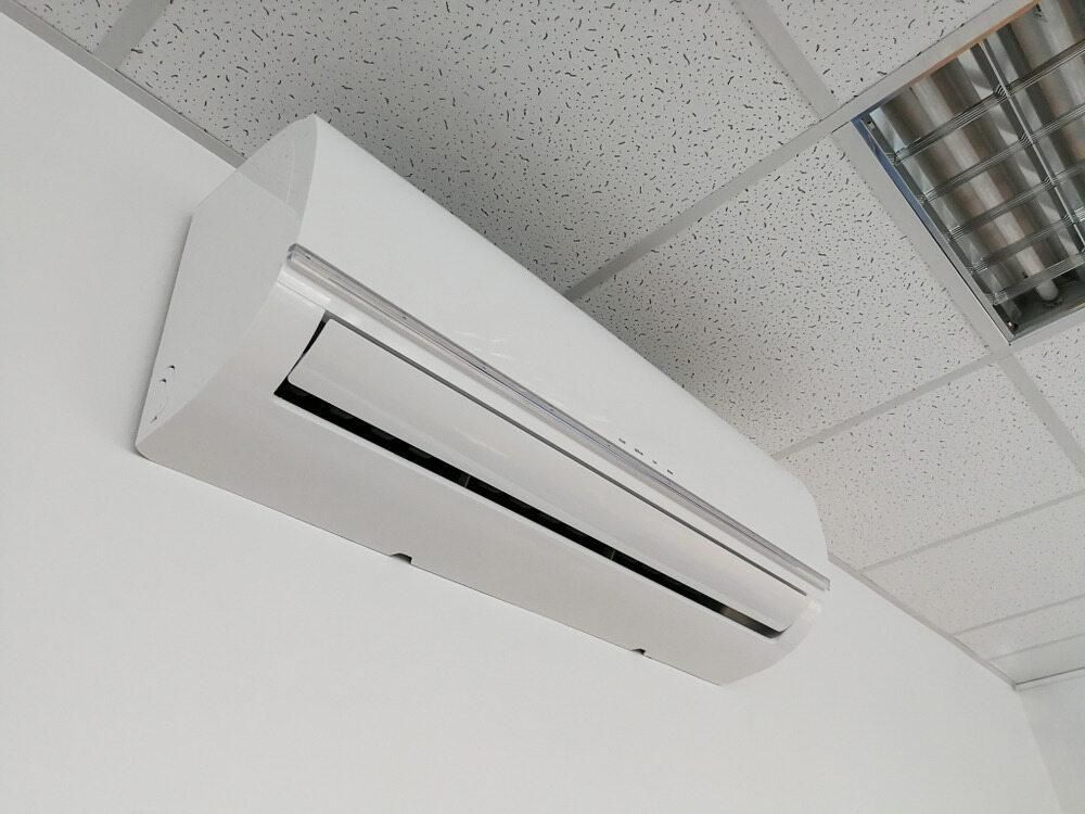 A White Air Conditioner is Mounted to a White Wall — AJM's Air Conditioning Centre in Broadwater, NSW