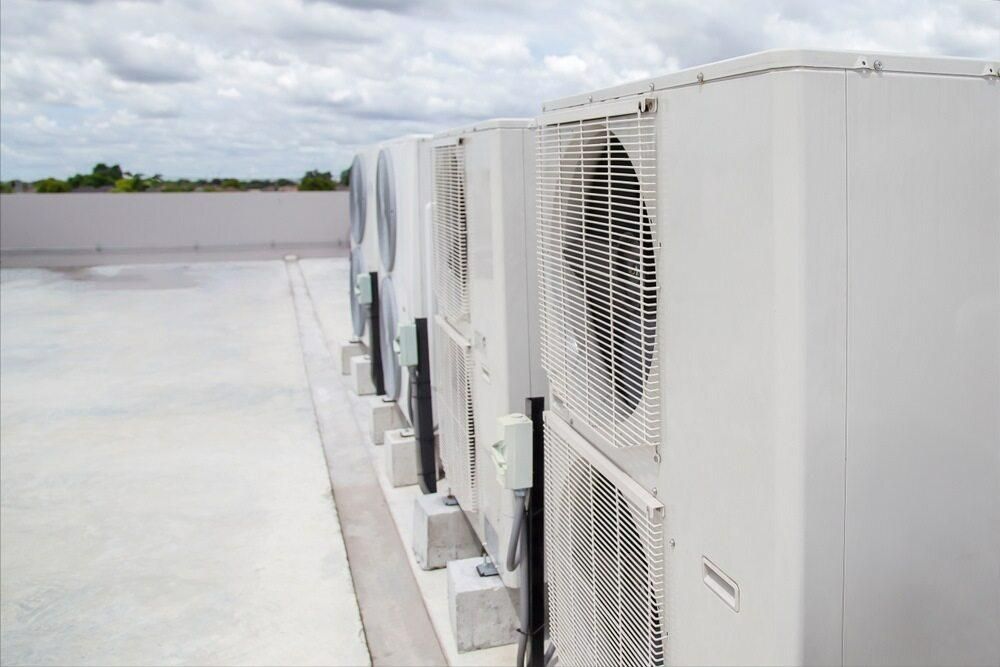 A Row of Air Conditioners Are Lined Up on the Side of a Building — AJM's Air Conditioning Centre in Broadwater, NSW