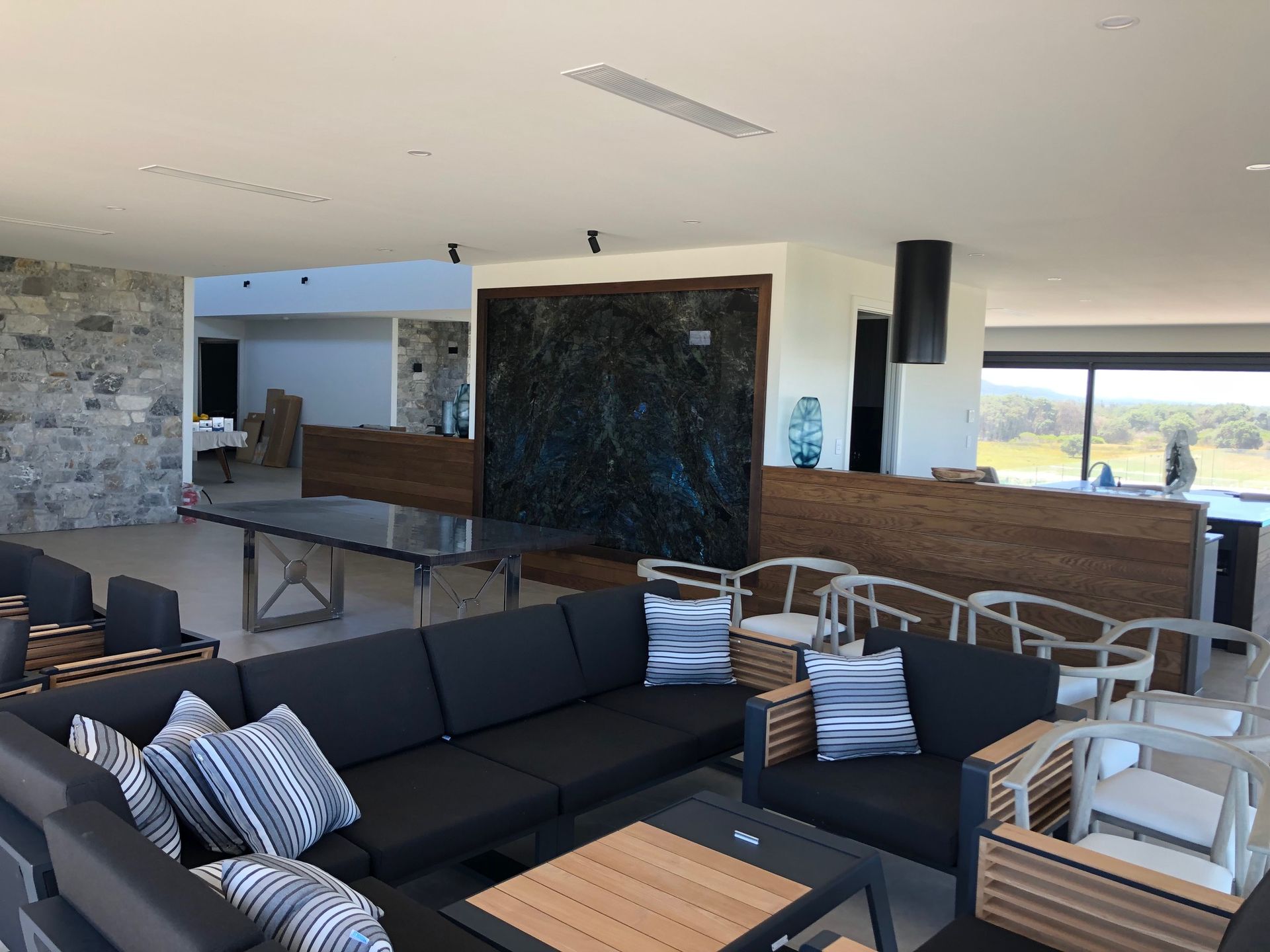 A living room with a black couch and air con unit above — AJM's Air Conditioning Centre in Lismore, NSW