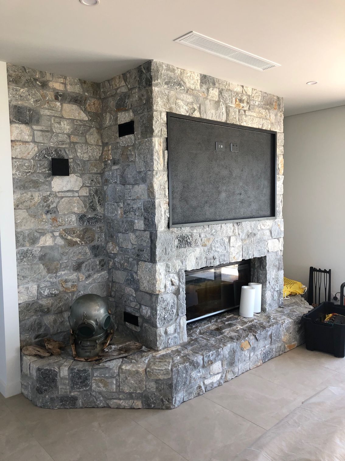 A Rock wall with a hire unit and air con unit above — AJM's Air Conditioning Centre in Lismore, NSW