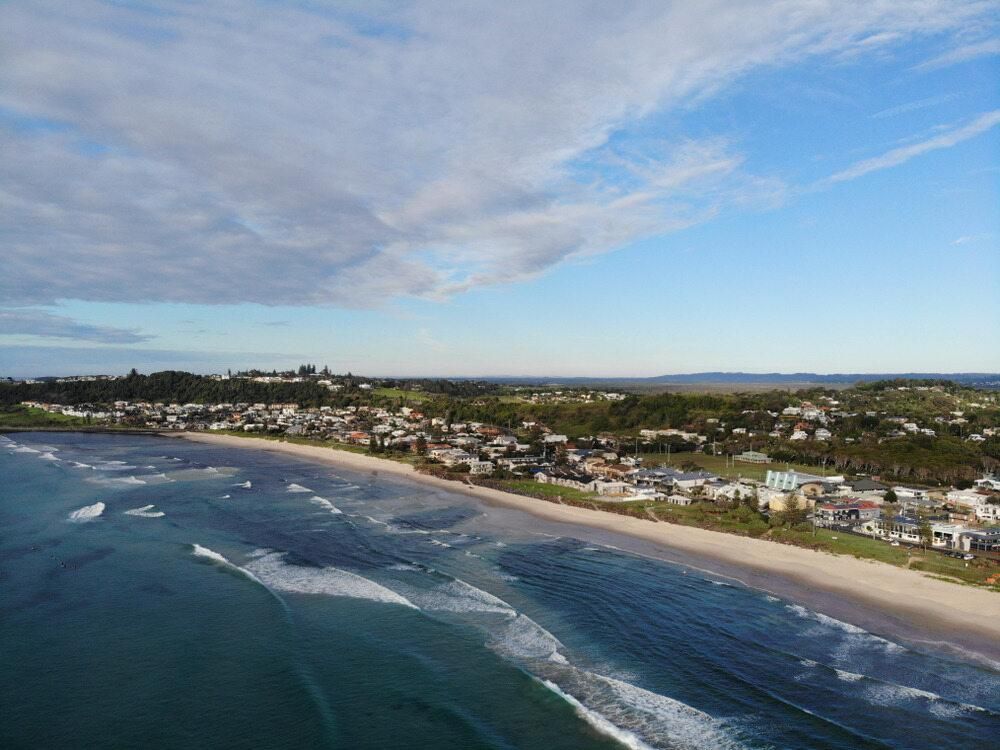 An Aerial View of a Beach With Waves Crashing on the Shore — AJM's Air Conditioning Centre in Lennox Head, NSW