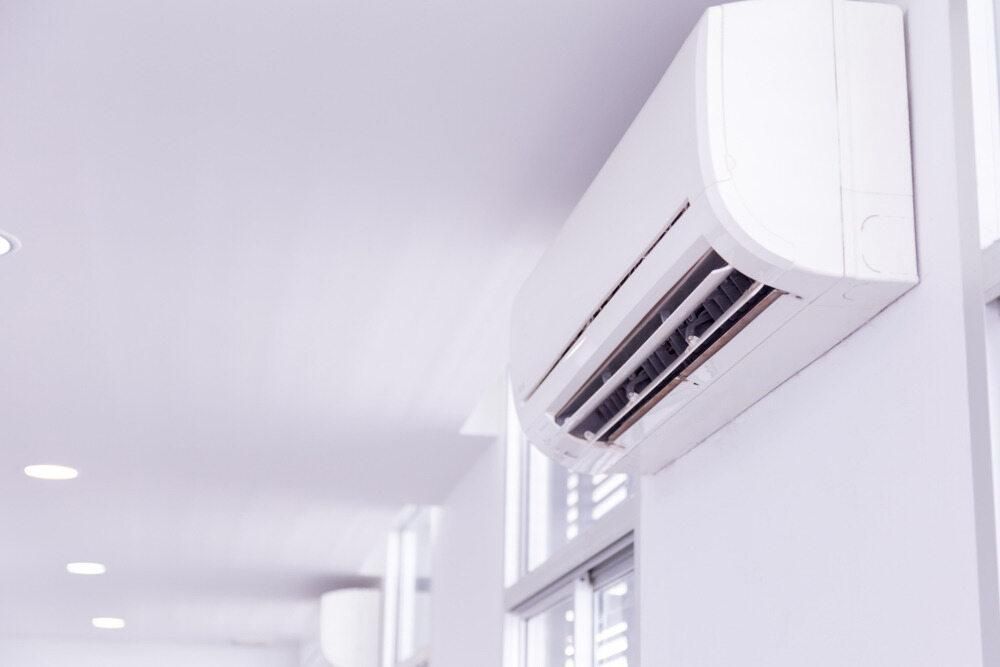 A White Air Conditioner is Hanging on a White Wall in a Hallway — AJM's Air Conditioning Centre in Lismore, NSW