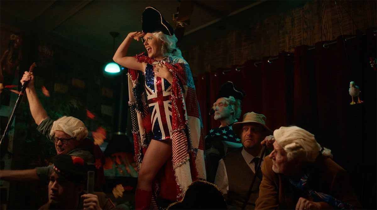 A woman in a costume is singing into a microphone in front of a crowd.