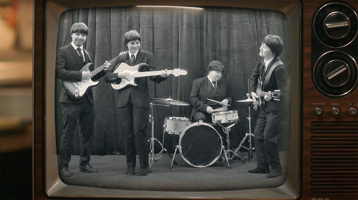 A black and white photo of the beatles on a television screen.