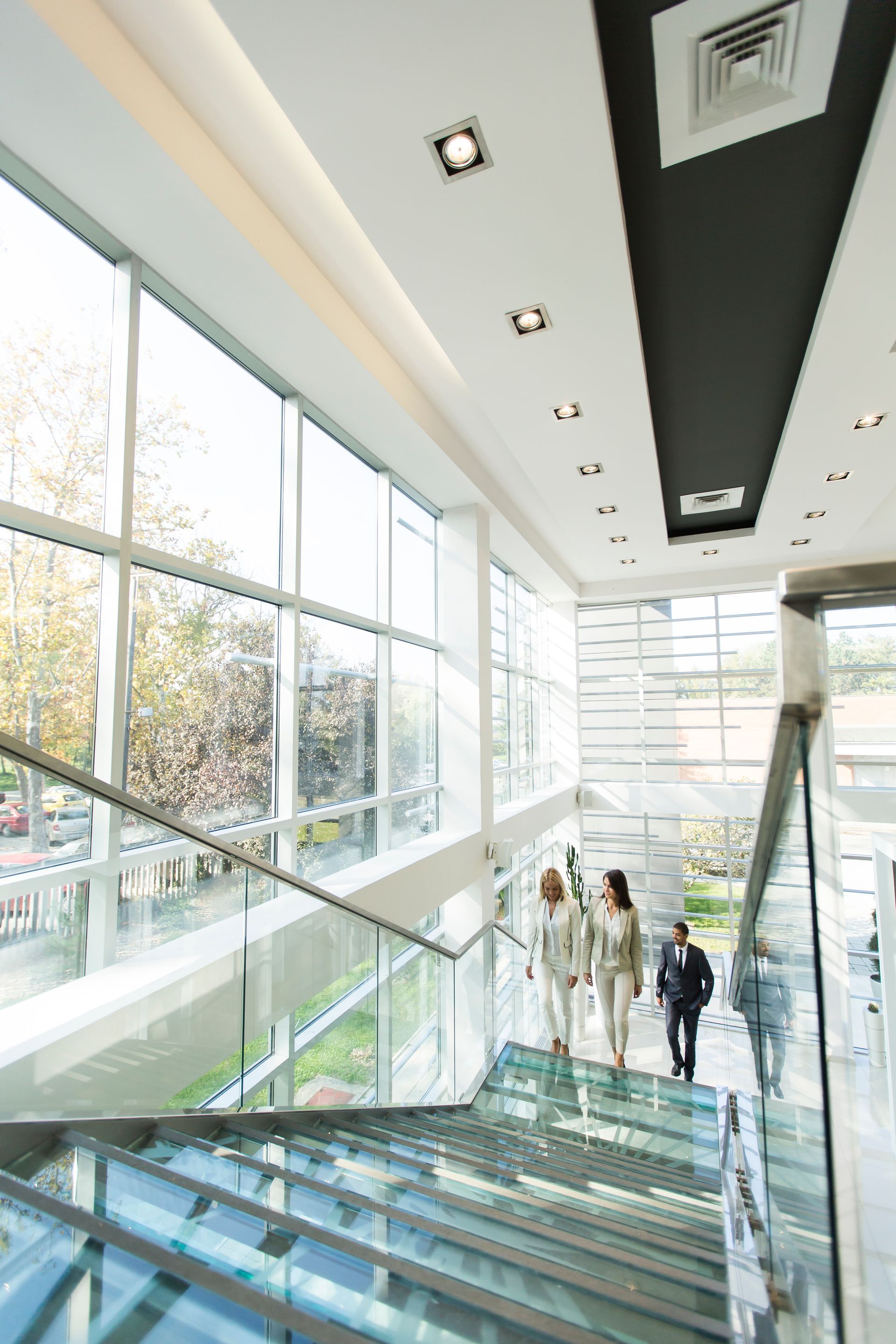 A group of people are walking down a set of stairs in a building.