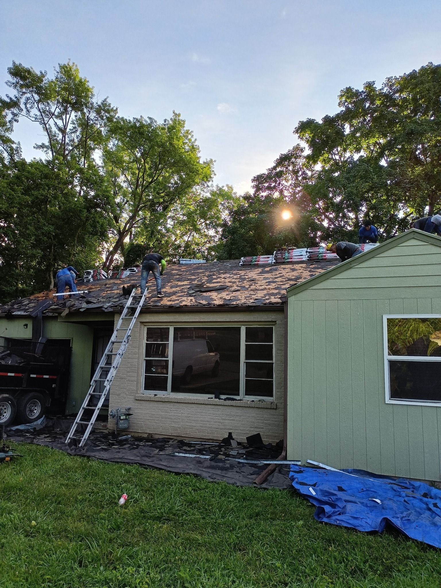 A group of people are working on the roof of a house.