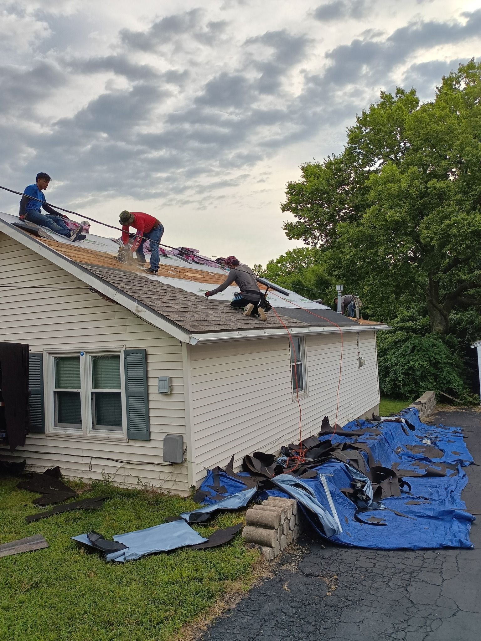 A group of men are working on the roof of a house.