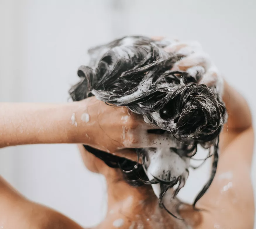 Tubo de champú fortalecedor Herbalife, blanco con detalles verdes, que presenta un diseño de hoja de aloe vera.