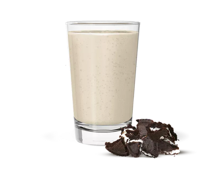 Envase de batido Herbalife Nutrition con sabor “Cookies & Cream”; vaso de batido con cuchara.
