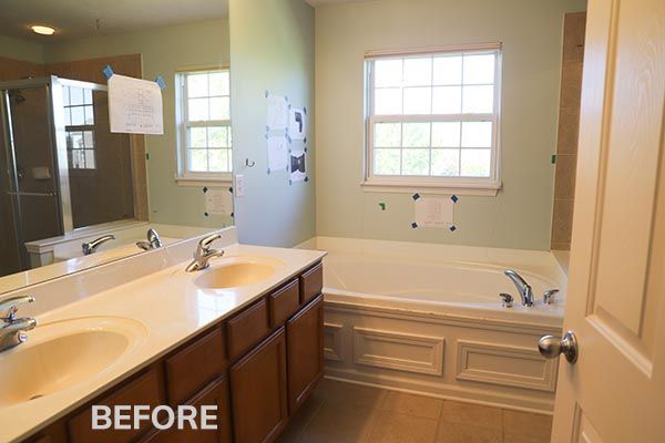 Bathroom vanity with two sinks, large mirror, and windows, labeled “before” in the lower left.