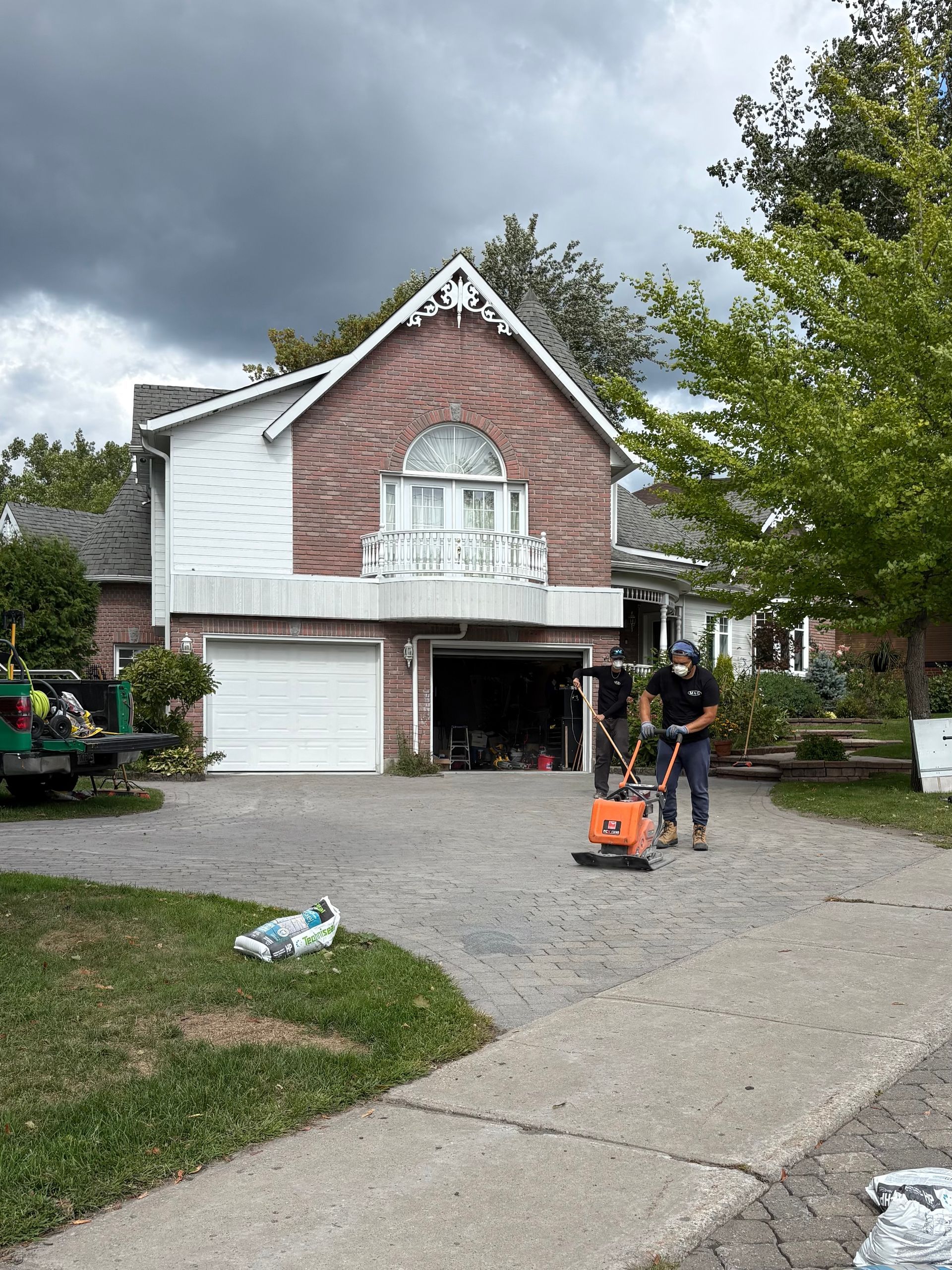 A man is cleaning the side of a brick building with a hose.