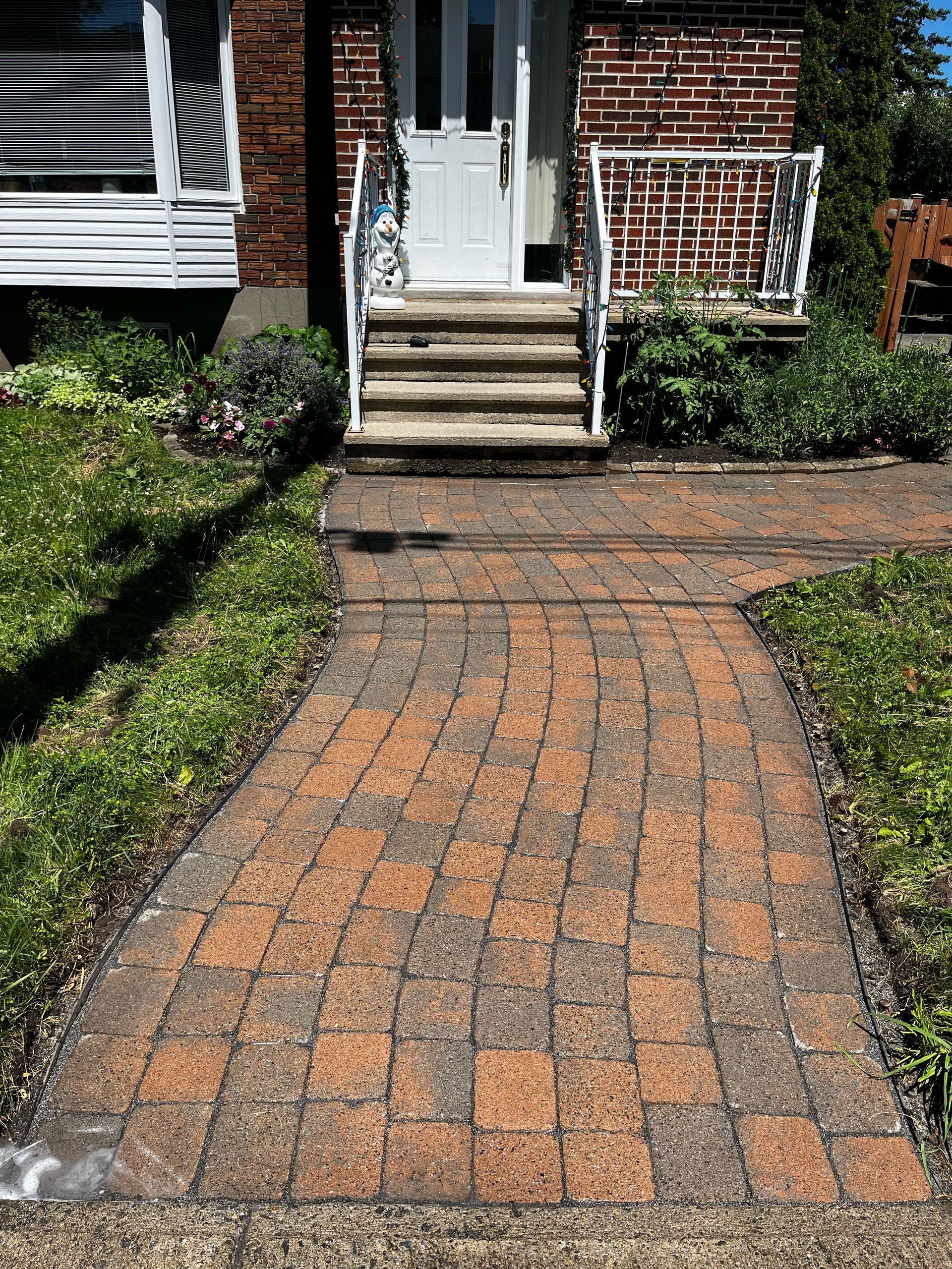 Une allée en briques menant à la porte d'entrée d'une maison.