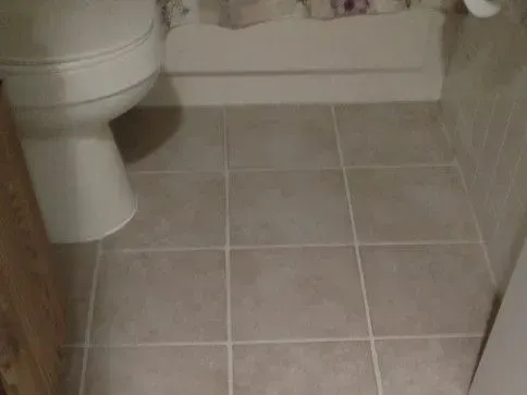 After - Cleaning a beige tile floor in a bathroom