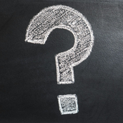 White chalk question mark on a blackboard background