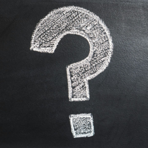 White chalk question mark on a blackboard background