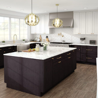 Bright modern kitchen with dark island, white cabinets, marble countertops, and gold pendant lights